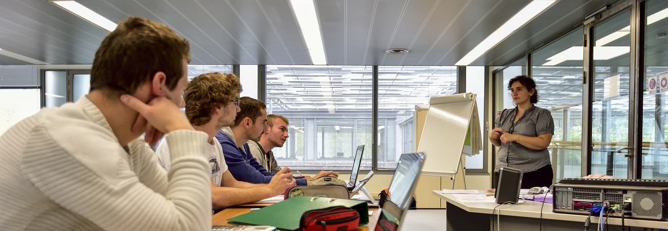 Groupe de 4 étudiants en train de suivre un cour sur leur ordinateur portable